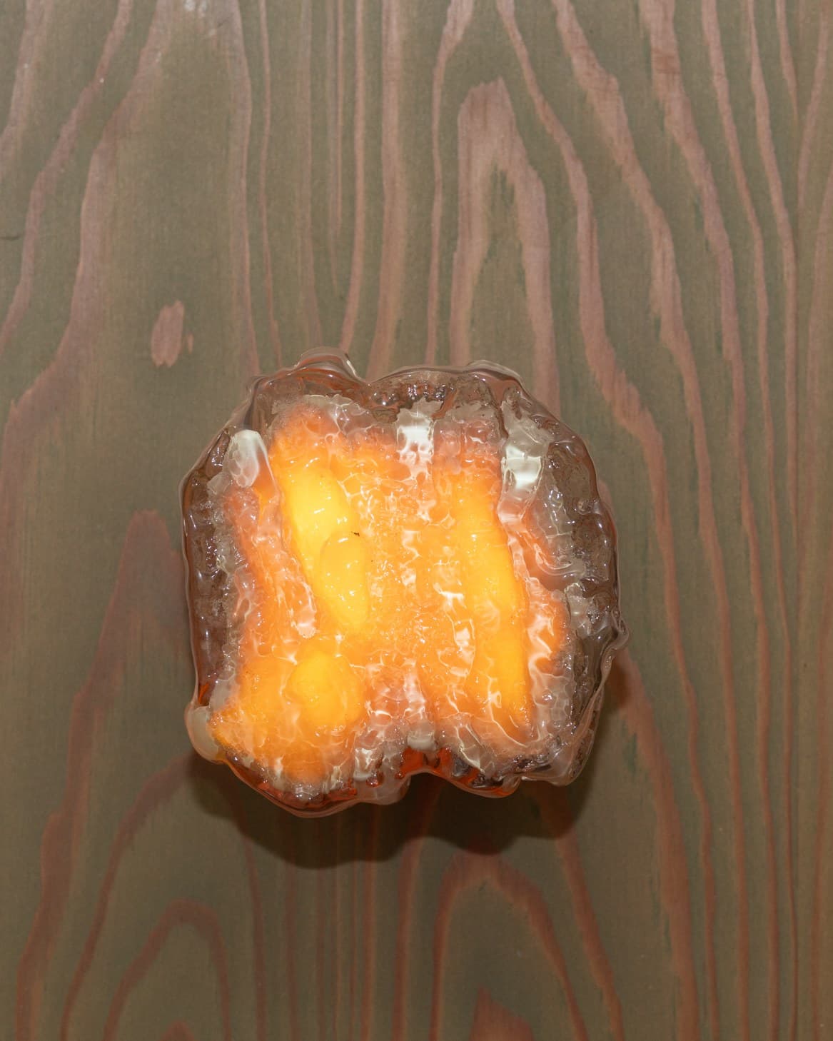 Orange pour, lit, on grey fir