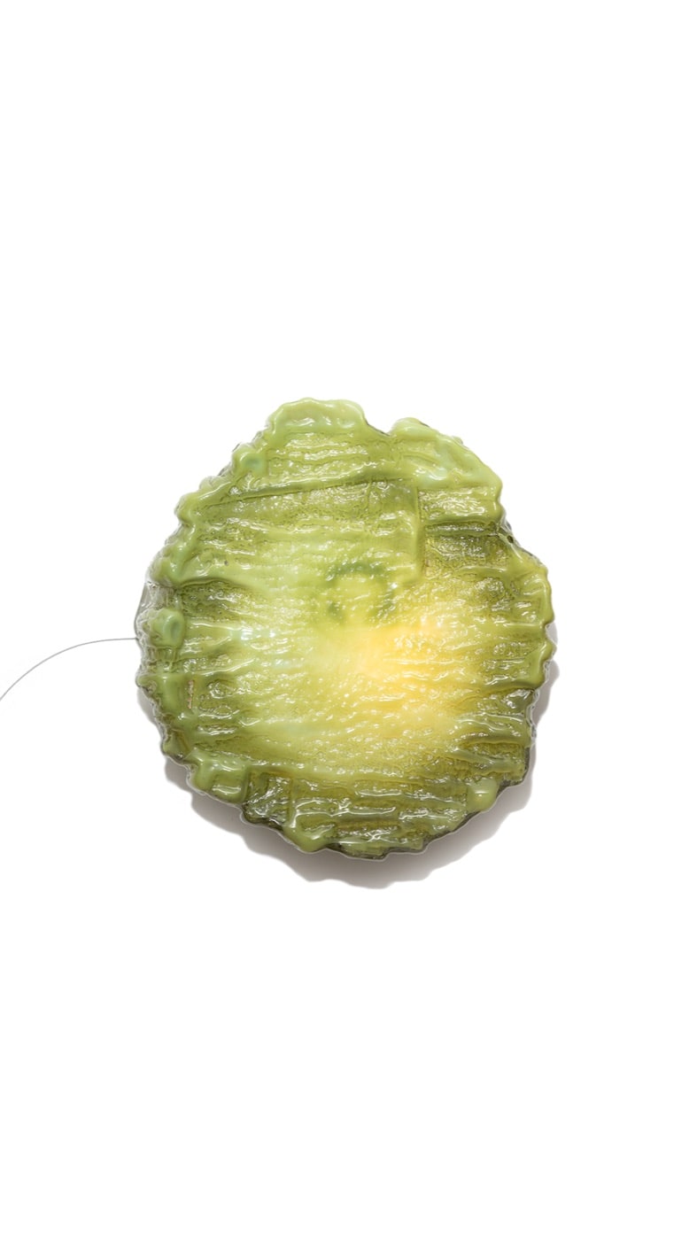 The Sconce's kelp green pour, lit, on white