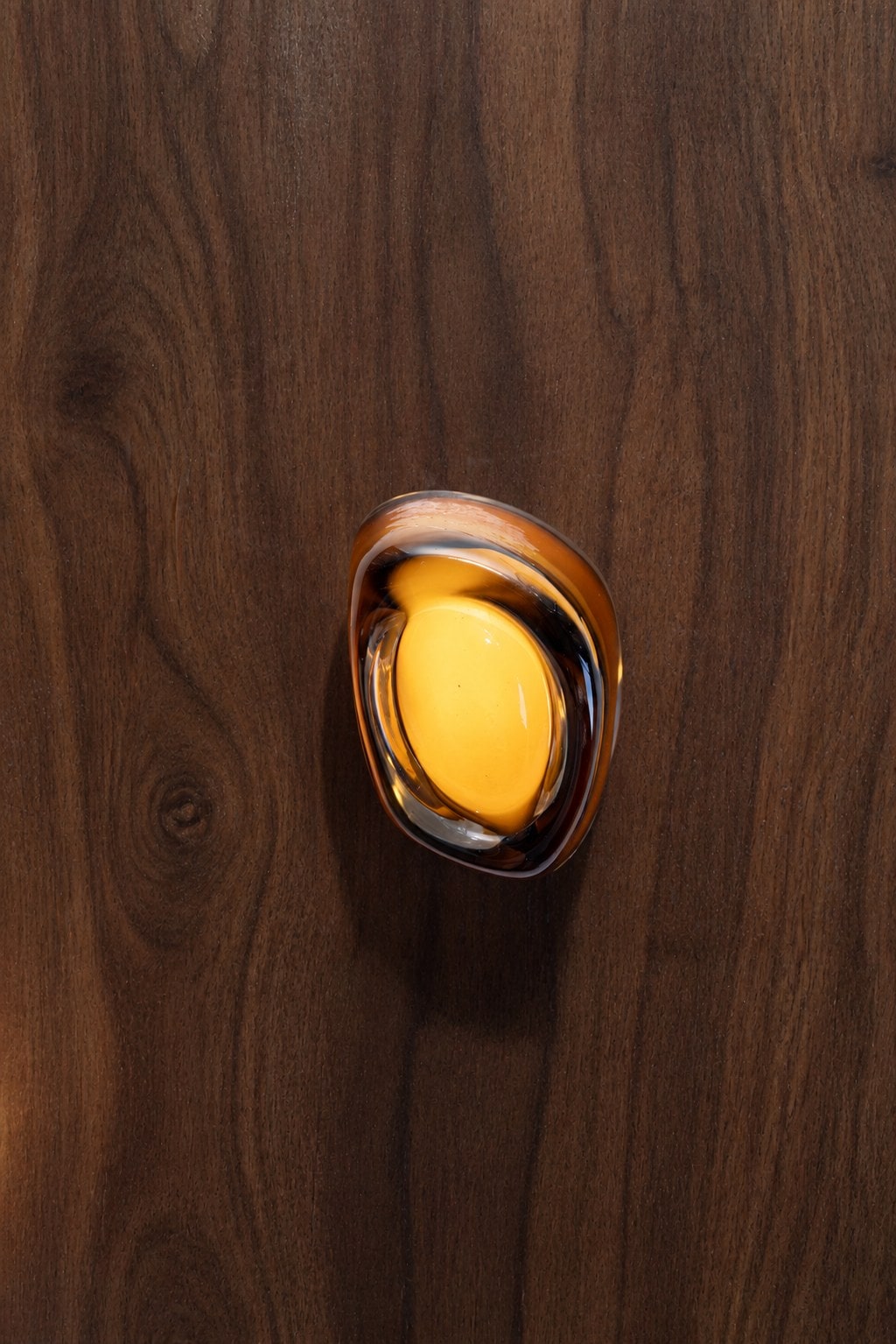 Amber pour, lit, on walnut