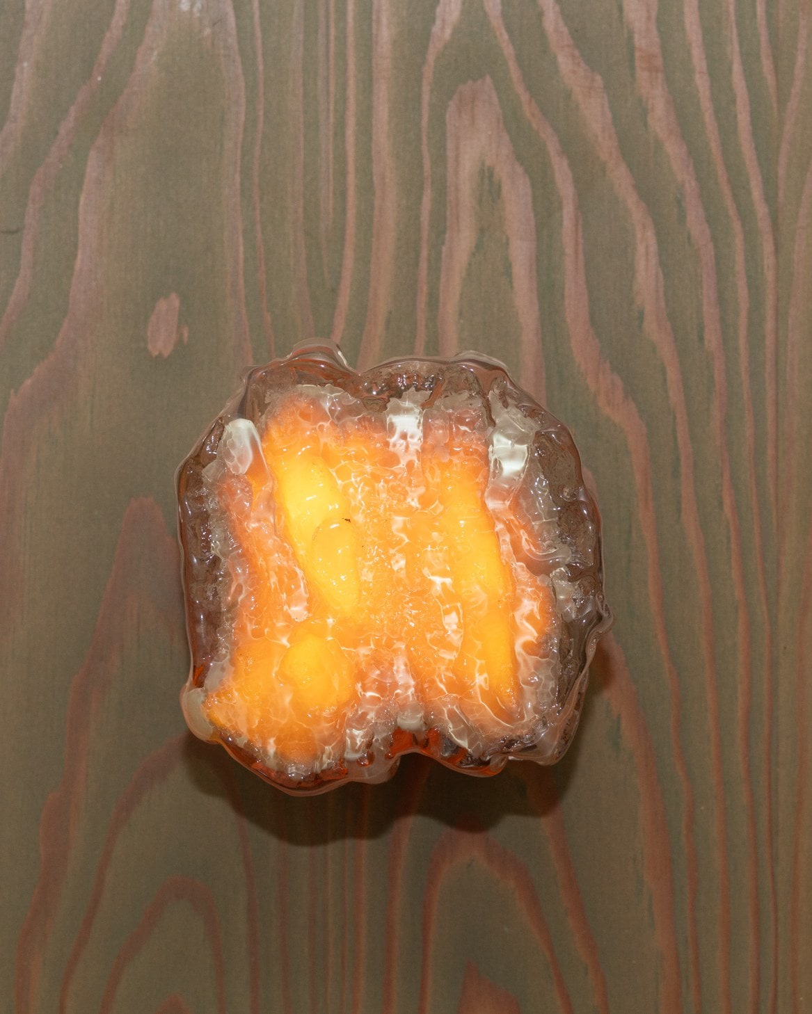 Orange pour, lit, on grey fir